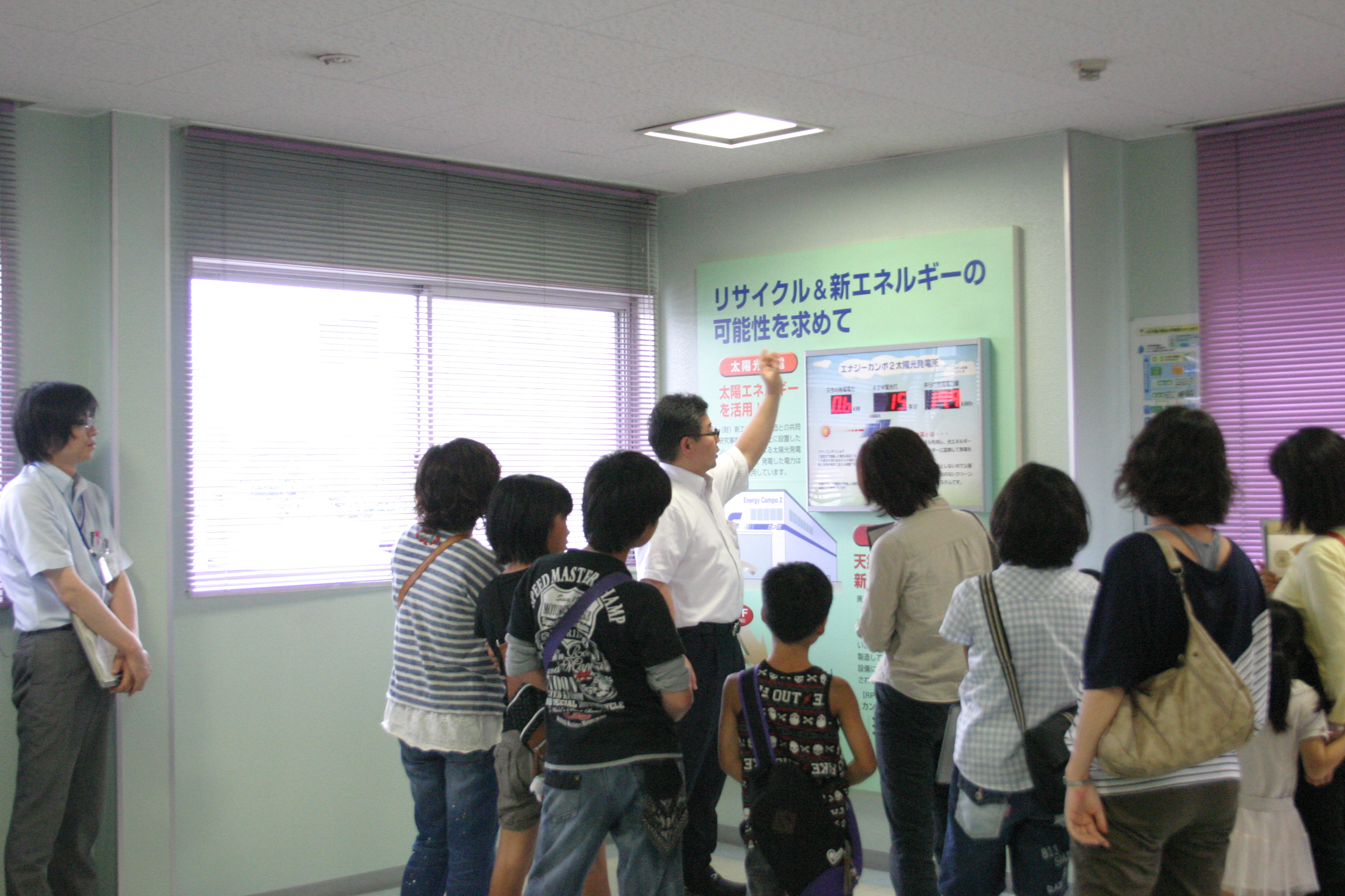 太陽光発電の説明を受ける見学者